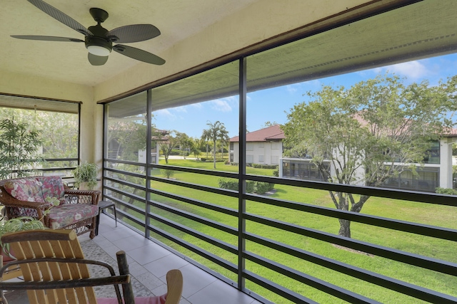 sunroom featuring a residential view and ceiling fan
