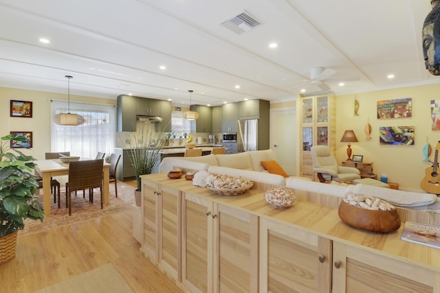 kitchen with a ceiling fan, visible vents, appliances with stainless steel finishes, tasteful backsplash, and light wood finished floors