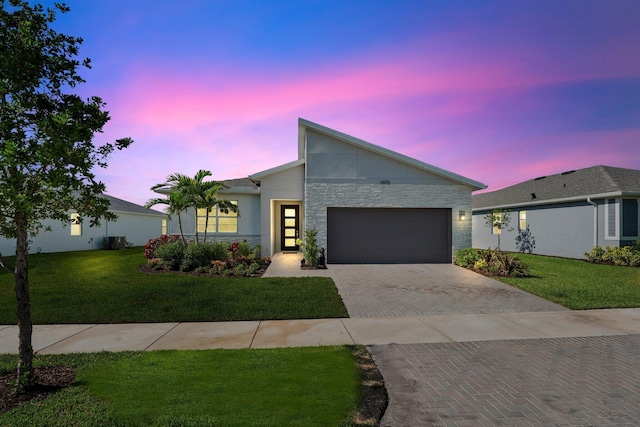 14175 SW Harker St, Port Saint Lucie, FL 34987 - view of front of home featuring decorative driveway, a garage, a lawn, and stucco siding