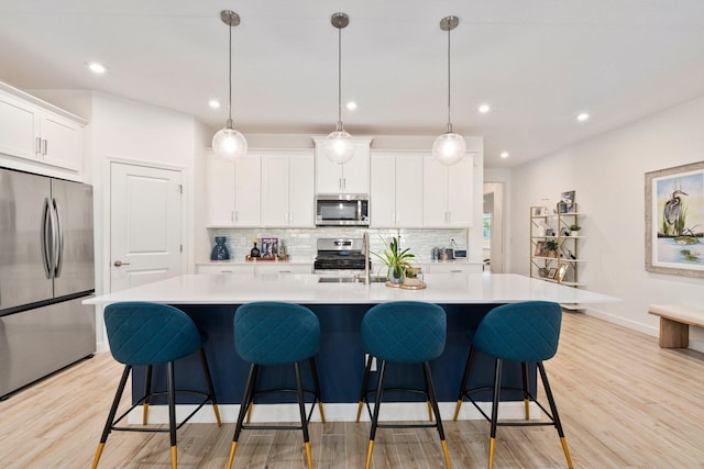 14175 SW Harker St, Port Saint Lucie, FL 34987 - kitchen featuring appliances with stainless steel finishes, backsplash, light wood-style flooring, light countertops, and recessed lighting
