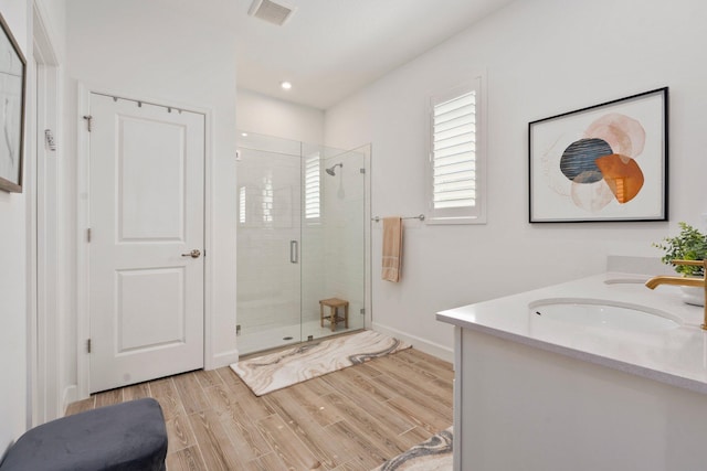 14175 SW Harker St, Port Saint Lucie, FL 34987 - bathroom with a stall shower, wood finished floors, double vanity, baseboards, and recessed lighting