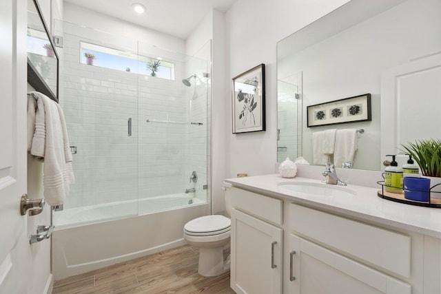 14175 SW Harker St, Port Saint Lucie, FL 34987 - bathroom featuring wood finished floors, toilet, vanity, shower / bath combination with glass door, and recessed lighting