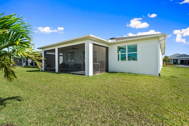 14175 SW Harker St, Port Saint Lucie, FL 34987 - back of house featuring a sunroom, a yard, and stucco siding