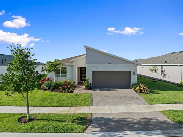 14175 SW Harker St, Port Saint Lucie, FL 34987 - view of front of property with a garage, decorative driveway, and a front lawn