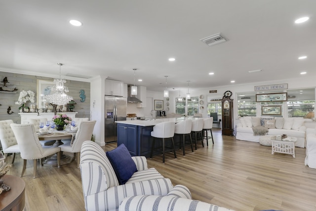 18315 SE Courtview Cir, Tequesta, FL 33469 - living room with recessed lighting, visible vents, ornamental molding, and light wood-type flooring