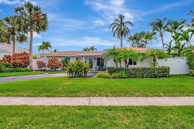 ranch-style house featuring fence, a gate, stucco siding, and a front lawn