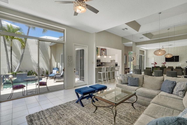 living area featuring ceiling fan, visible vents, and tile patterned floors