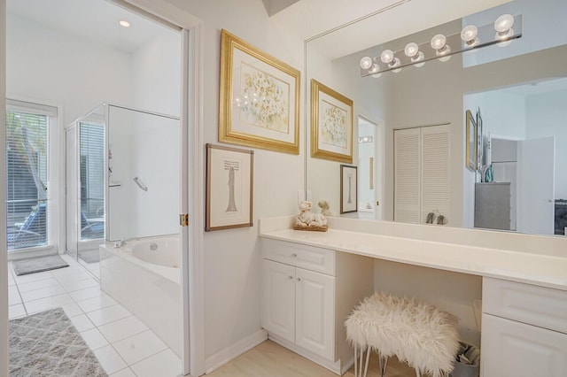 bathroom with a stall shower, tile patterned floors, a bath, and vanity