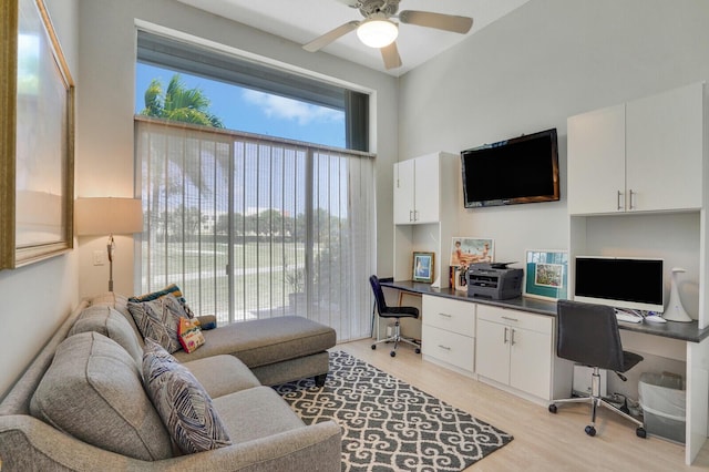 office featuring ceiling fan, light wood-style flooring, and built in desk