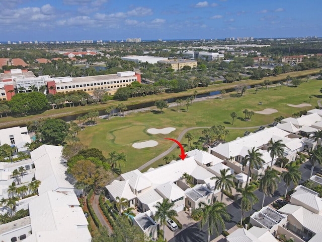 birds eye view of property with view of golf course and a water view