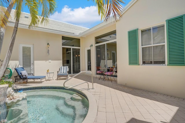 rear view of house with a patio area, stucco siding, and an outdoor pool