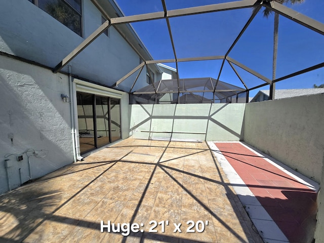 view of patio featuring glass enclosure