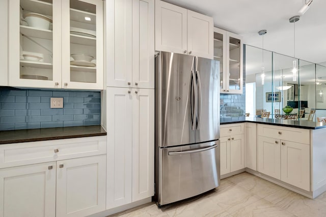 44 Cocoanut Row Unit 507A, Palm Beach, FL 33480 - kitchen featuring freestanding refrigerator, dark countertops, a peninsula, tasteful backsplash, and glass insert cabinets