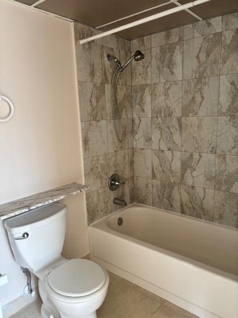 bathroom with shower / bathing tub combination, tile patterned floors, and toilet