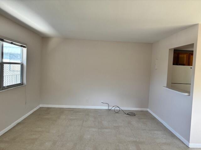 unfurnished room featuring baseboards