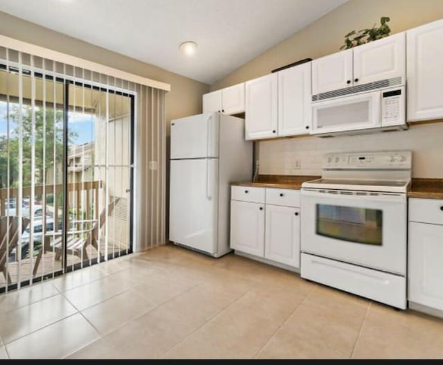 13135 Chadwick Ct Unit 7, Wellington, FL 33414 - kitchen featuring white appliances, white cabinets, vaulted ceiling, dark countertops, and light tile patterned flooring