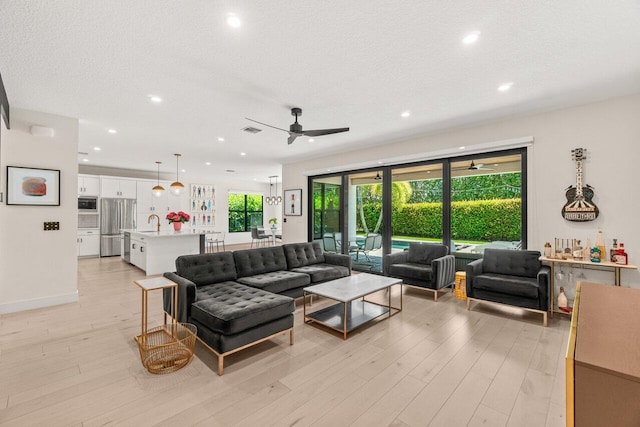 9610 Sterling Shores St, Delray Beach, FL 33446 - living room featuring ceiling fan, recessed lighting, light wood-style floors, and a textured ceiling