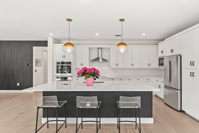9610 Sterling Shores St, Delray Beach, FL 33446 - kitchen with appliances with stainless steel finishes, wall chimney range hood, light wood finished floors, and light countertops