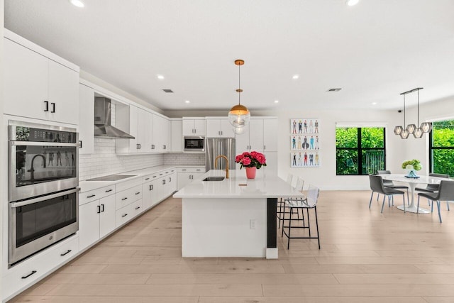 9610 Sterling Shores St, Delray Beach, FL 33446 - kitchen with wall chimney exhaust hood, stainless steel appliances, a sink, white cabinets, and light countertops