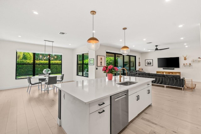 9610 Sterling Shores St, Delray Beach, FL 33446 - kitchen with stainless steel dishwasher, a sink, light countertops, light wood-style flooring, and recessed lighting