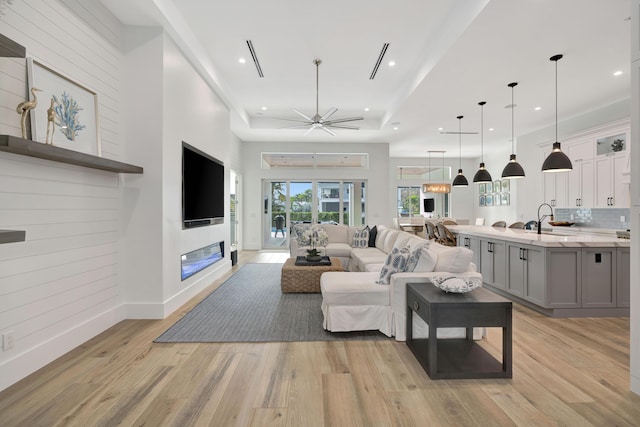 living room with recessed lighting, baseboards, a ceiling fan, and light wood finished floors