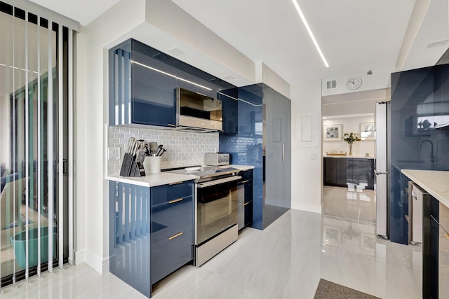4600 S Ocean Blvd Unit 1003, Highland Beach, FL 33487 - kitchen featuring appliances with stainless steel finishes, modern cabinets, blue cabinetry, tasteful backsplash, and light countertops