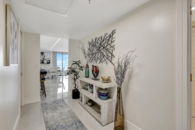hall featuring baseboards and visible vents