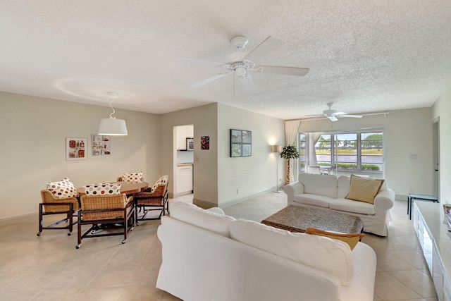 14612 Canalview Dr Unit B, Delray Beach, FL 33484 - living room featuring light tile patterned floors, baseboards, ceiling fan, and a textured ceiling