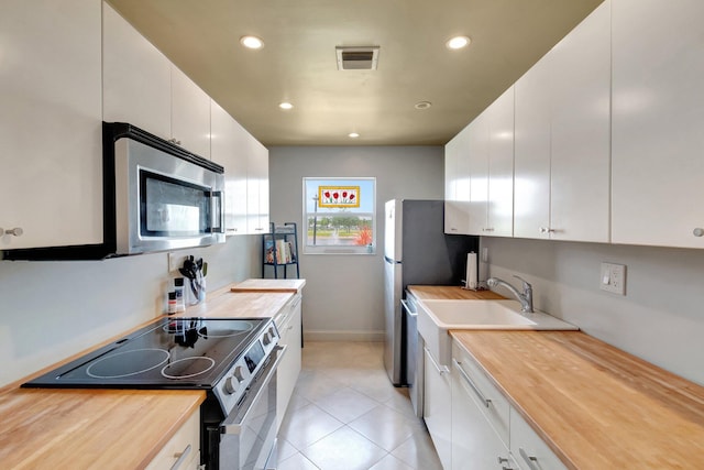 14612 Canalview Dr Unit B, Delray Beach, FL 33484 - kitchen with visible vents, light tile patterned floors, stainless steel appliances, recessed lighting, and butcher block countertops