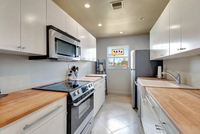 14612 Canalview Dr Unit B, Delray Beach, FL 33484 - kitchen featuring visible vents, butcher block counters, recessed lighting, white cabinets, and appliances with stainless steel finishes