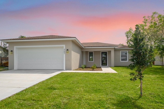4657 SW Keats St, Port Saint Lucie, FL 34953 - view of front facade featuring driveway, an attached garage, a lawn, and stucco siding