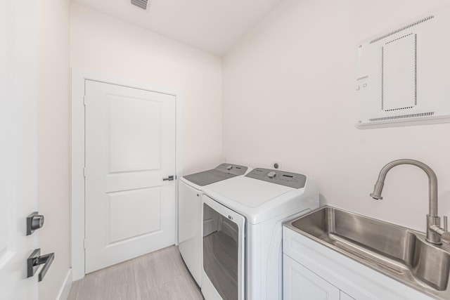 4657 SW Keats St, Port Saint Lucie, FL 34953 - laundry room with washer and dryer, cabinet space, and light wood-type flooring