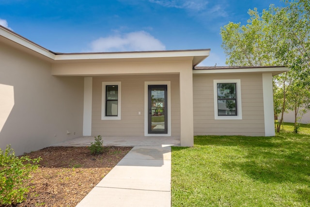 4657 SW Keats St, Port Saint Lucie, FL 34953 - doorway to property featuring a lawn and stucco siding
