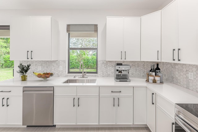 4657 SW Keats St, Port Saint Lucie, FL 34953 - kitchen with stainless steel dishwasher, light countertops, tasteful backsplash, and white cabinetry