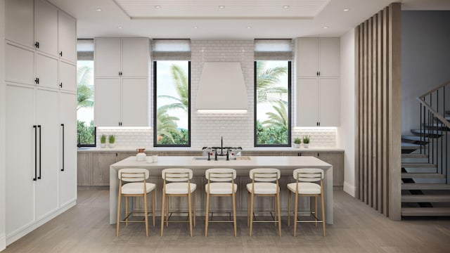 305 Grove Pl, Delray Beach, FL 33444 - kitchen featuring backsplash, a center island, light wood-type flooring, a sink, and healthy amount of natural light
