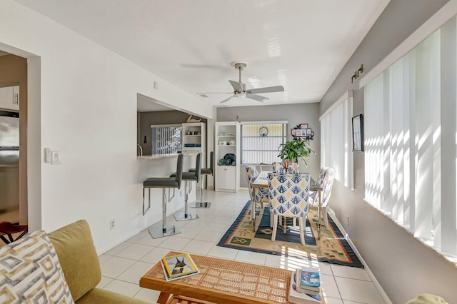 dining space featuring light tile patterned floors, baseboards, and ceiling fan
