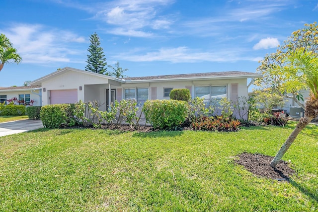 ranch-style house with a garage, stucco siding, and a front yard