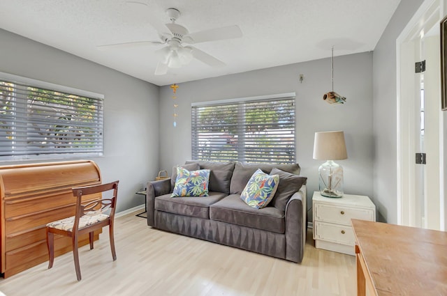 living room featuring a ceiling fan and light wood-type flooring