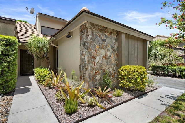 view of property exterior featuring stone siding and stucco siding