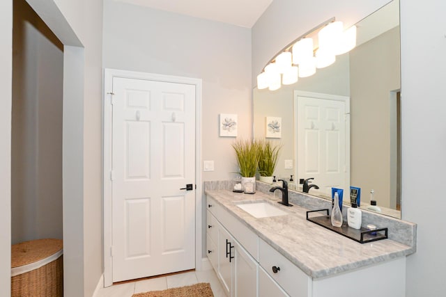 bathroom with vanity, tile patterned flooring, and baseboards