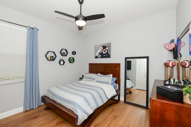 bedroom featuring baseboards, ceiling fan, and light wood-style floors