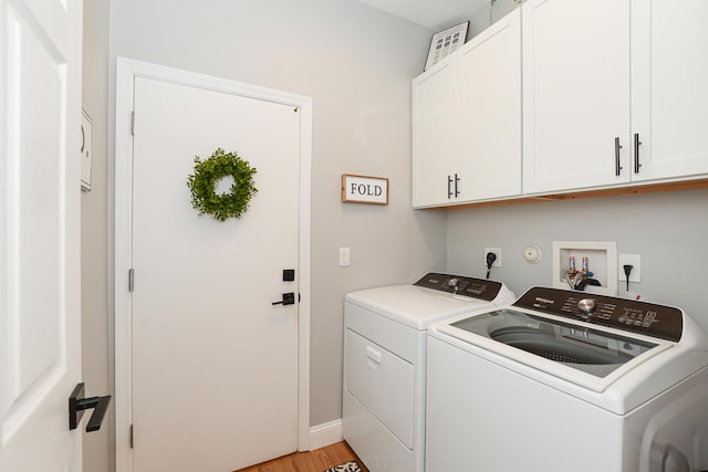 laundry area featuring cabinet space, separate washer and dryer, baseboards, and light wood-type flooring
