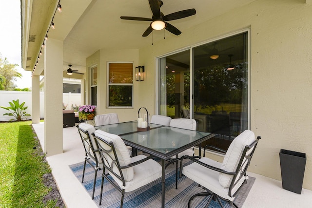 view of patio featuring fence, outdoor dining area, and ceiling fan
