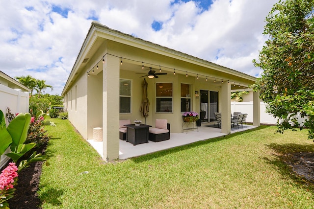 back of property with a ceiling fan, a patio area, fence, a yard, and stucco siding