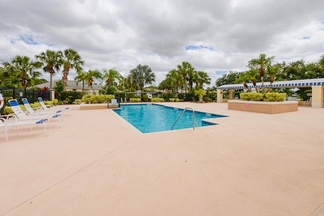 pool with fence and a patio area