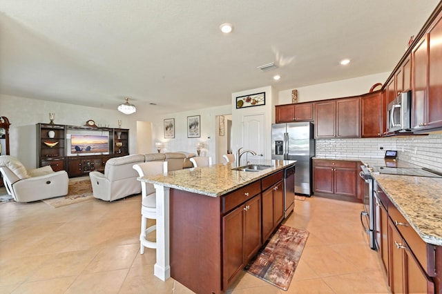 7384 NW Greenspring St, Port Saint Lucie, FL 34987 - kitchen with appliances with stainless steel finishes, a sink, open floor plan, a kitchen breakfast bar, and light tile patterned floors