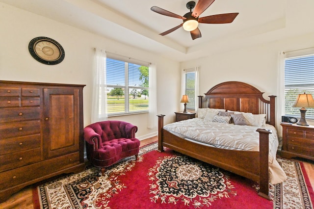 7384 NW Greenspring St, Port Saint Lucie, FL 34987 - bedroom with wood finished floors, a tray ceiling, ceiling fan, and baseboards