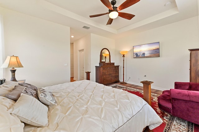 7384 NW Greenspring St, Port Saint Lucie, FL 34987 - bedroom with wood finished floors, a tray ceiling, baseboards, recessed lighting, and ceiling fan