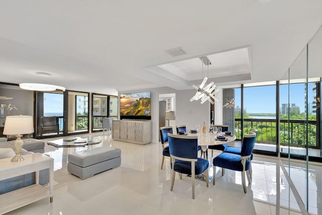 5380 N Ocean Dr Unit 5A, Riviera Beach, FL 33404 - tiled dining room with a wall of windows, a raised ceiling, plenty of natural light, and an inviting chandelier