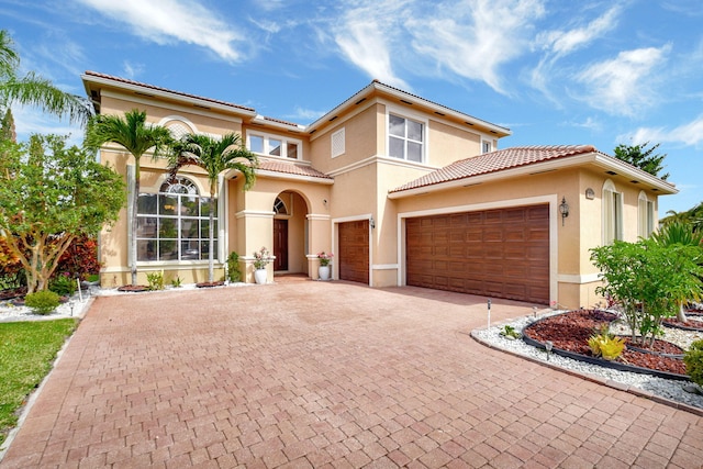 8841 Cobblestone Point Cir, Boynton Beach, FL 33472 - mediterranean / spanish home featuring decorative driveway, an attached garage, a tile roof, and stucco siding